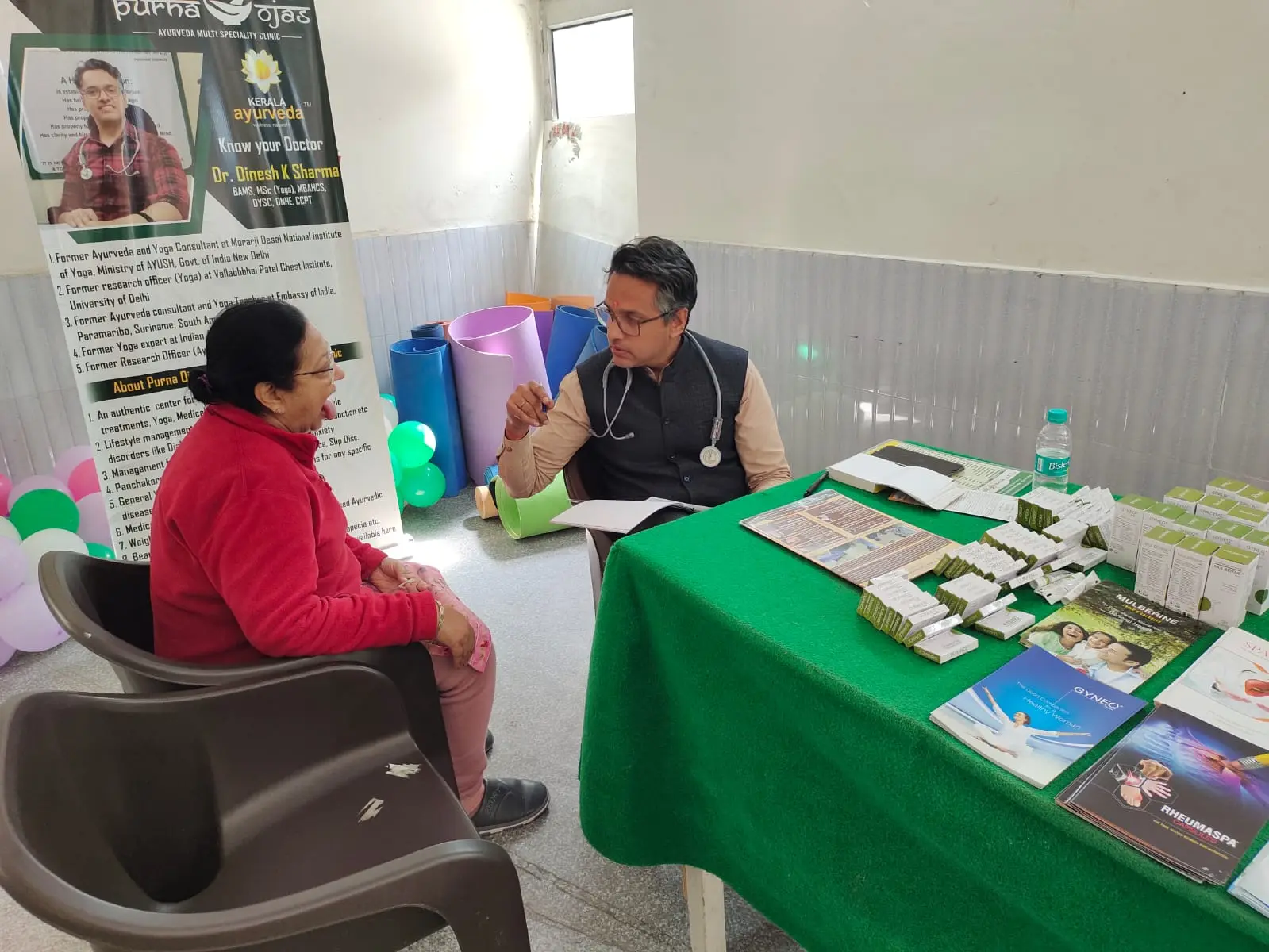 Dr. Dinesh Sharma providing an Ayurvedic consultation at the community camp