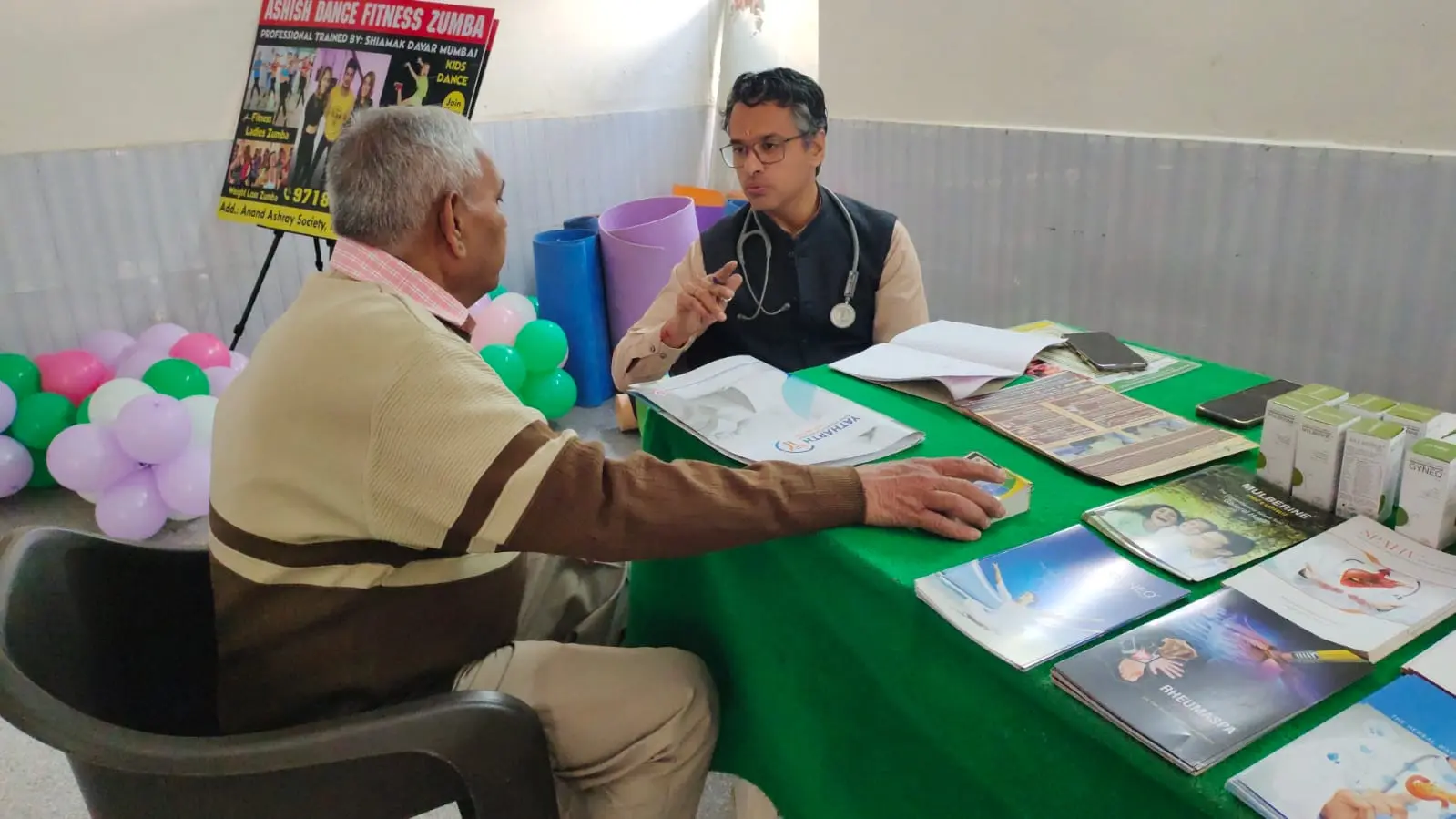 Dr. Dinesh Sharma speaking with a senior visitor at the camp
